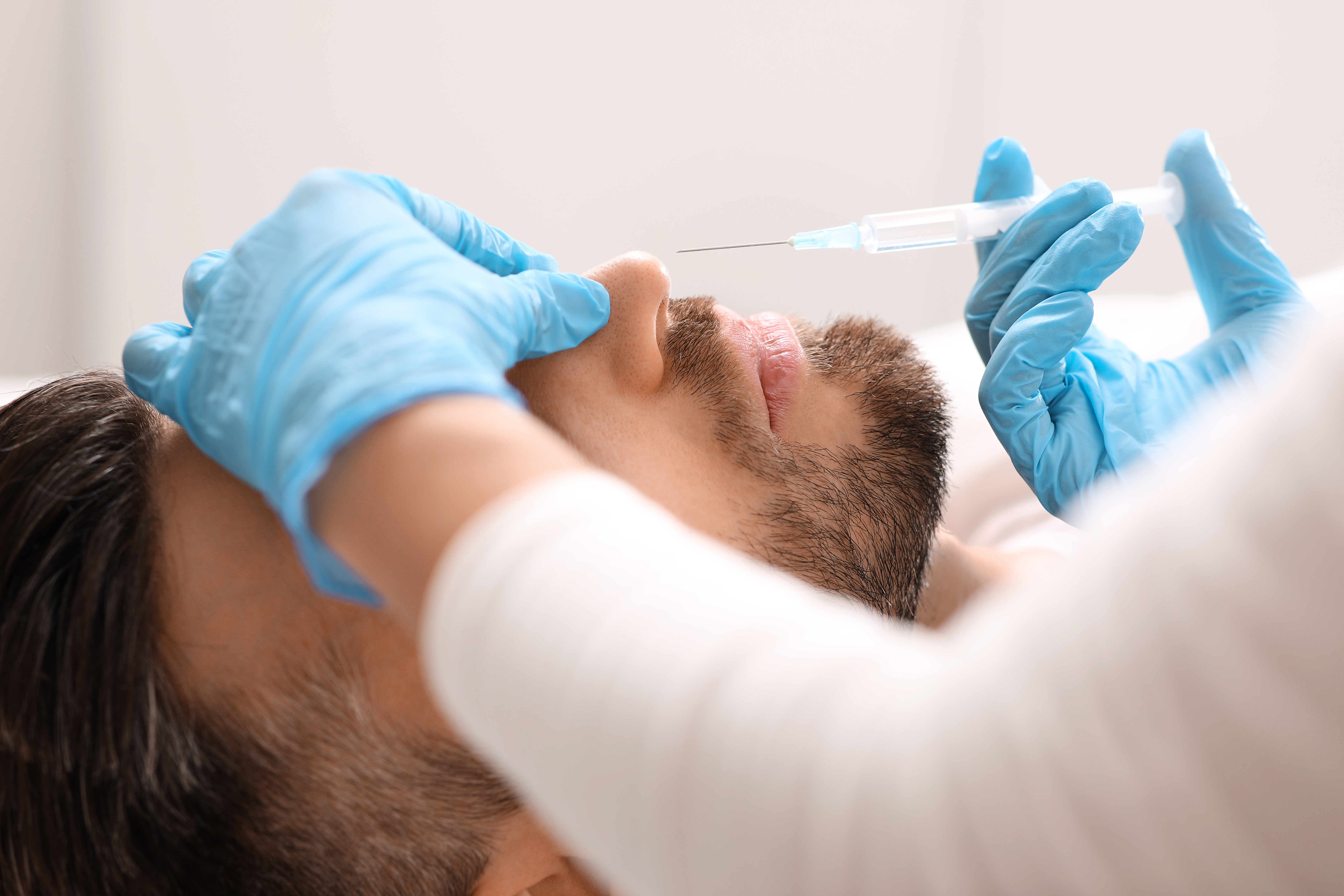 Rinomodelación y armonización del perfil nasal Profesional realizando un tratamiento estético no quirúrgico en la nariz