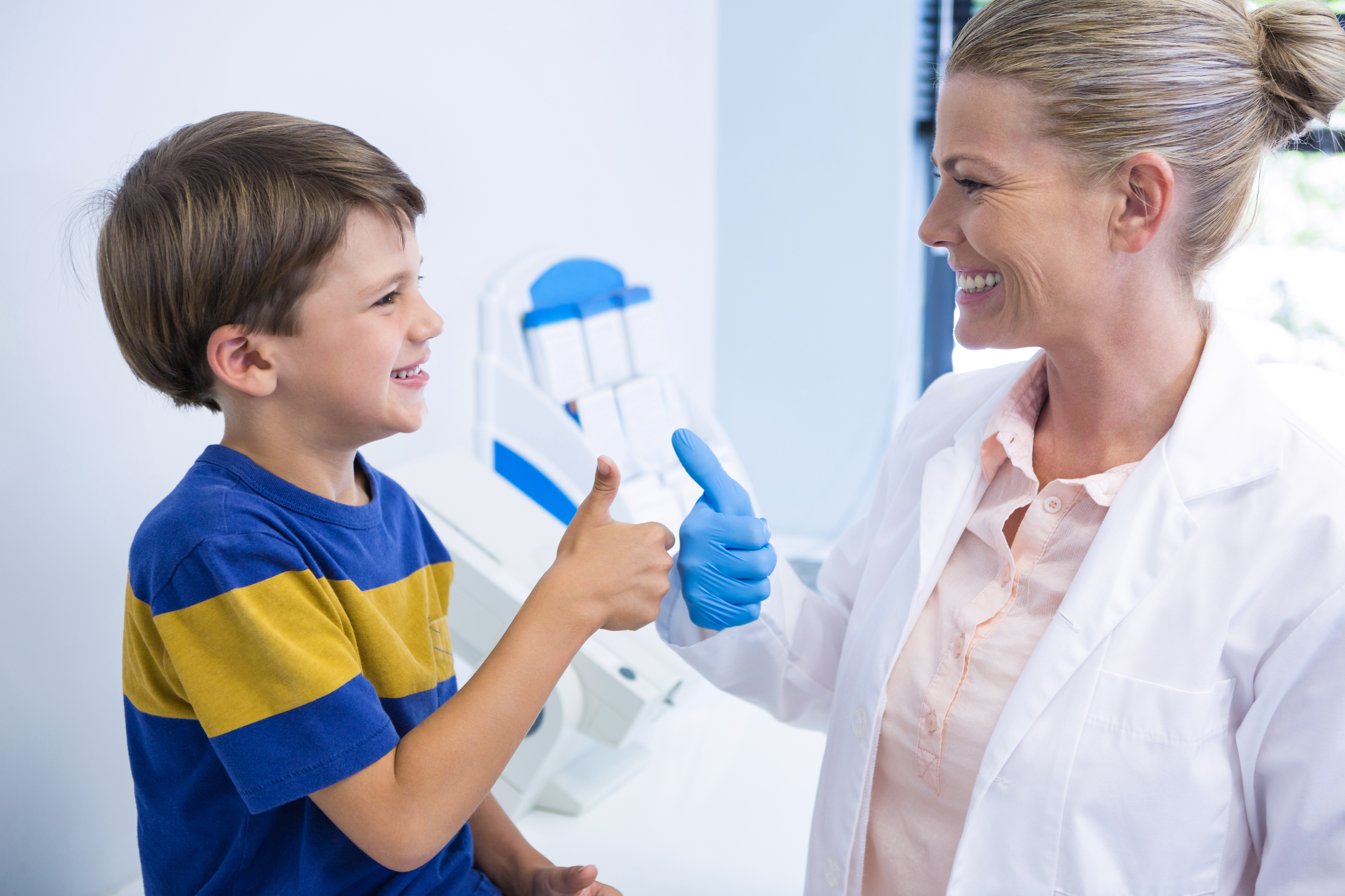 Visita al dentista para cuidar la salud oral infantil Dentista interactuando con un niño durante una consulta dental